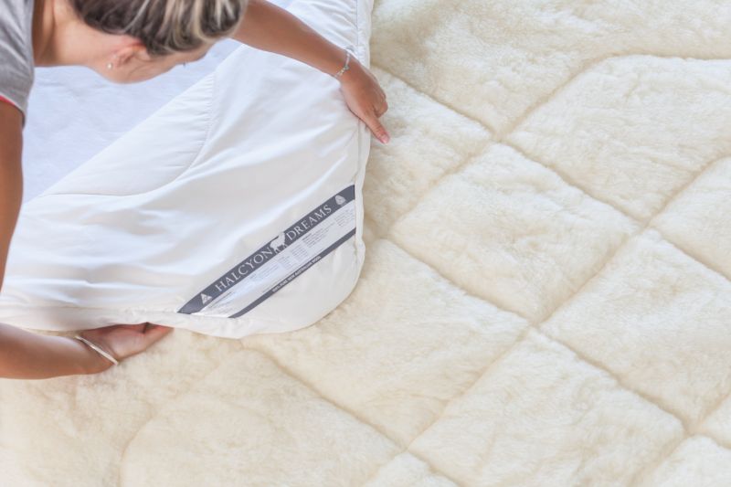 Girl putting sheets on bed